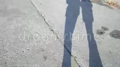 两名步行者在水泥石板路上的影子或轮廓